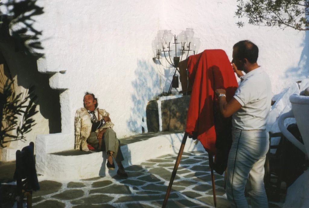 Dali sitting on the porch while a photographer takes a picture 