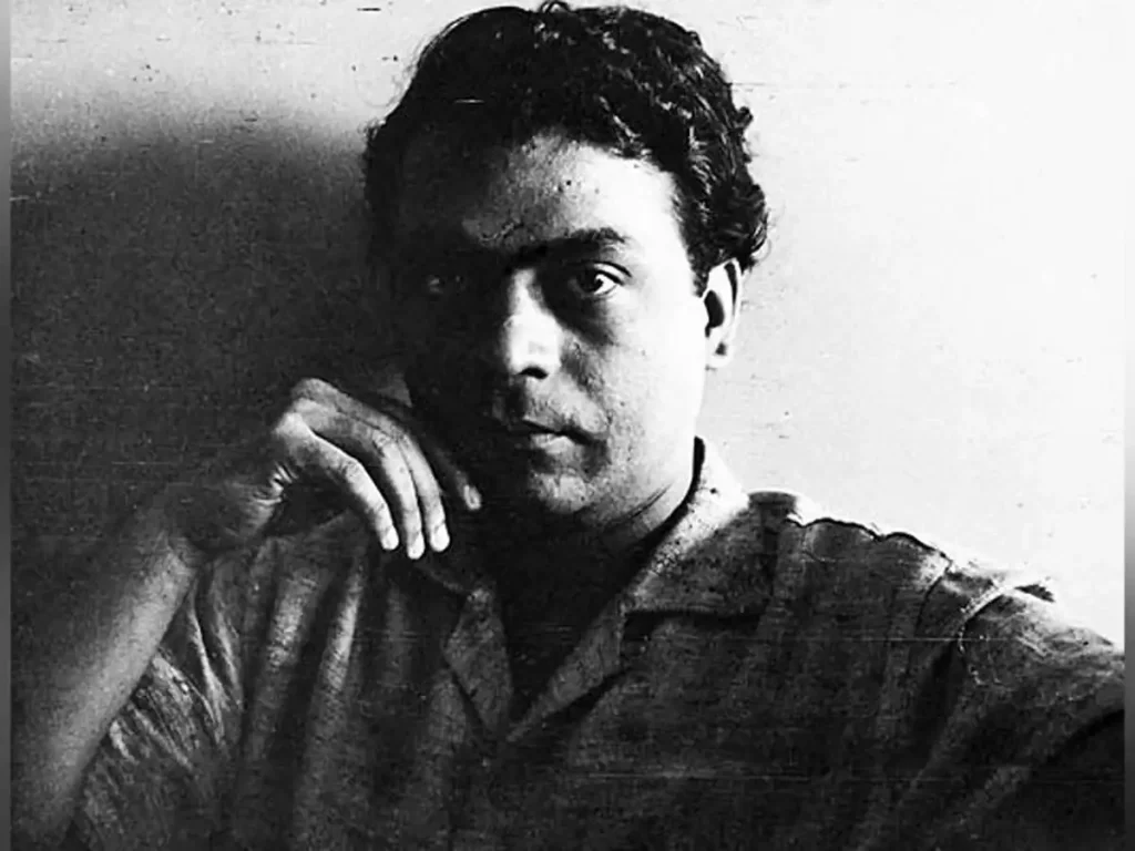 A black-and-white portrait of V. S. Gaitonde, an iconic Indian modernist artist, exuding a contemplative expression with his hand resting against his cheek. The minimal background emphasizes his thoughtful demeanor and artistic legacy.