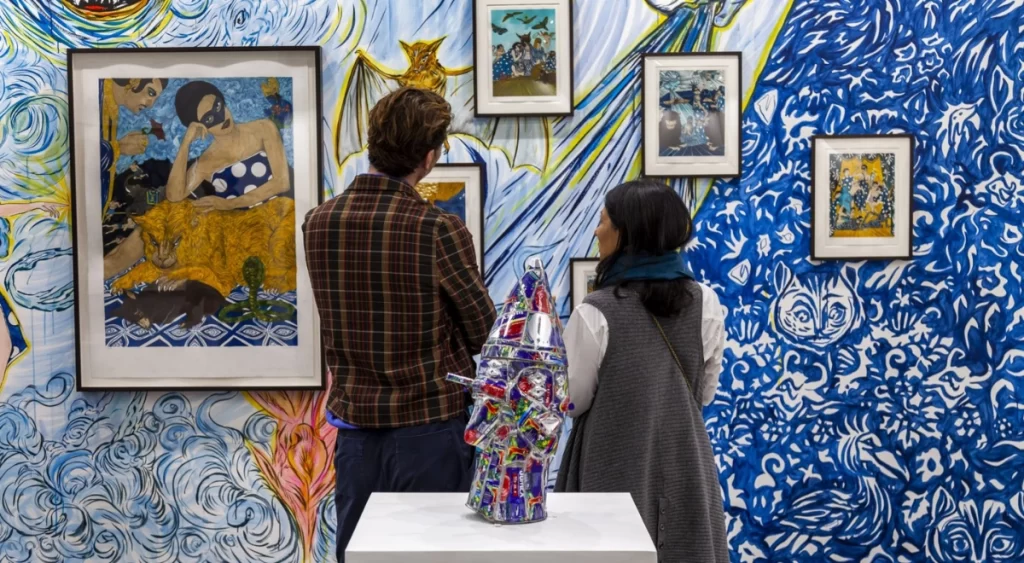 Two people admiring artwork hung on a wall 