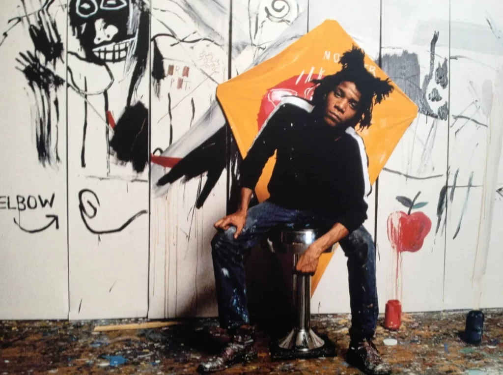 Jean-Michel Basquiat posing in front of his art