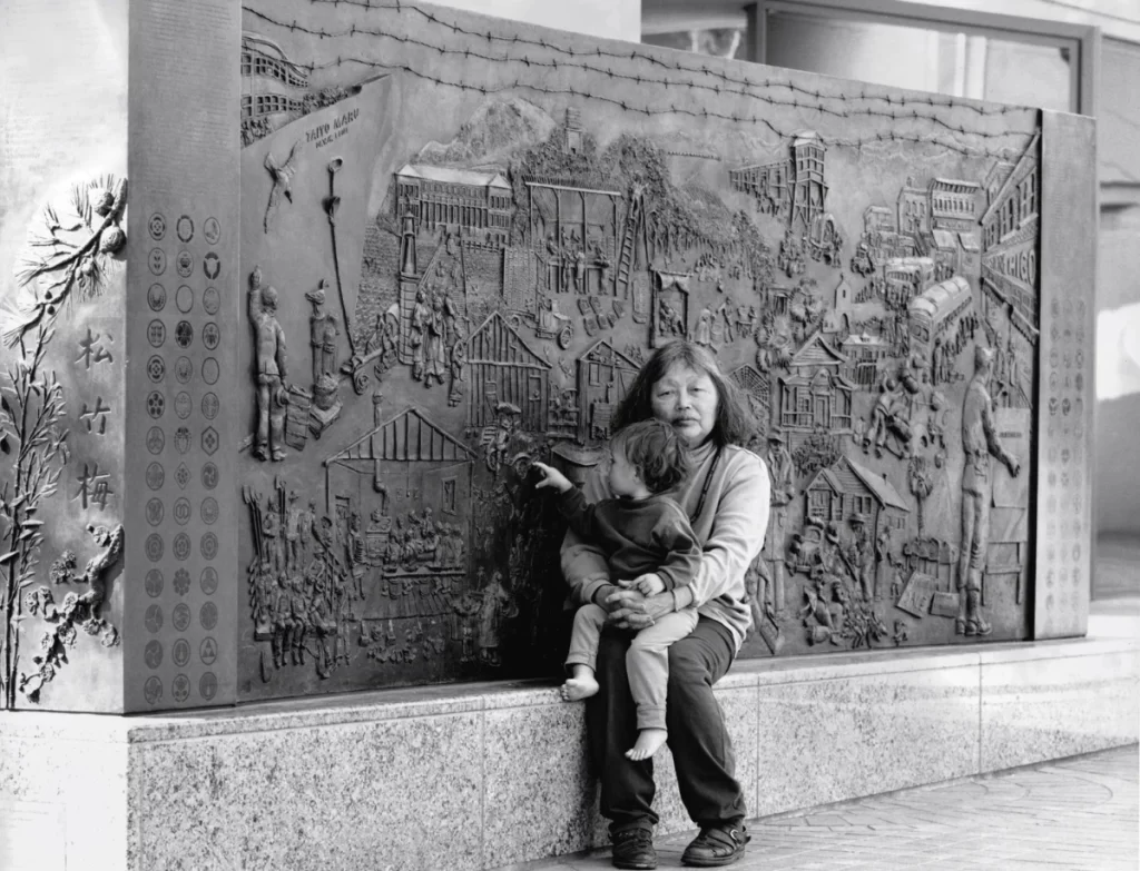 Ruth Asawa sitting in front of her work 