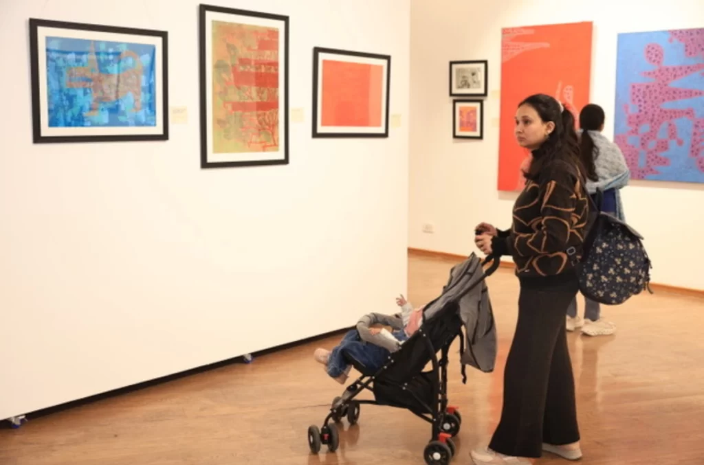 A visitor Looking at Lama Tyagi's artwork 